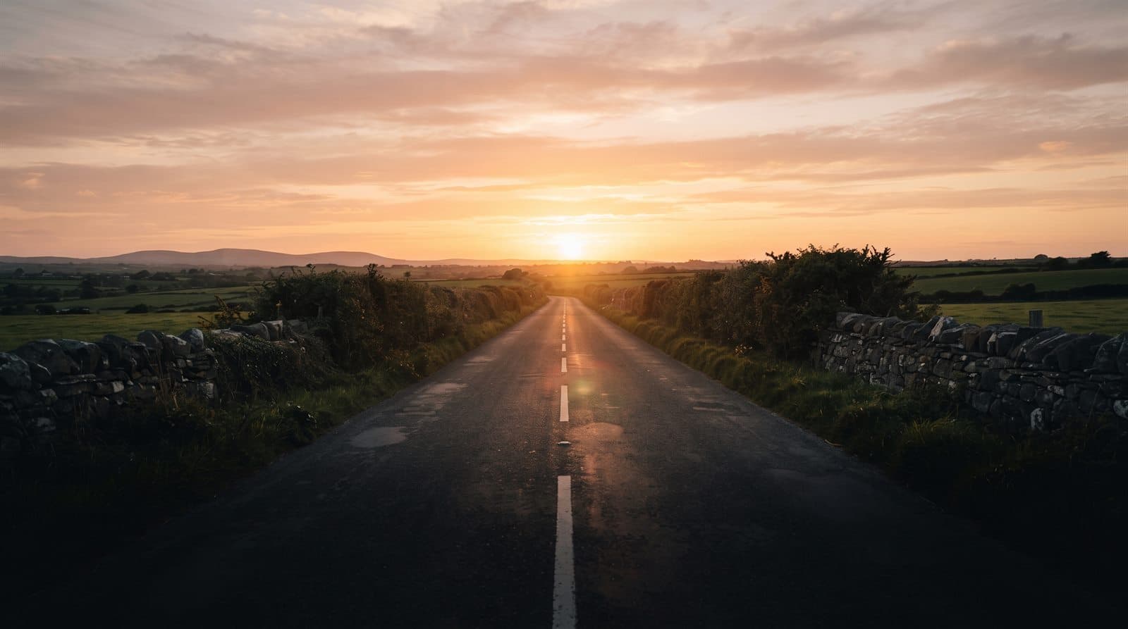 An empty country road running west at sunset