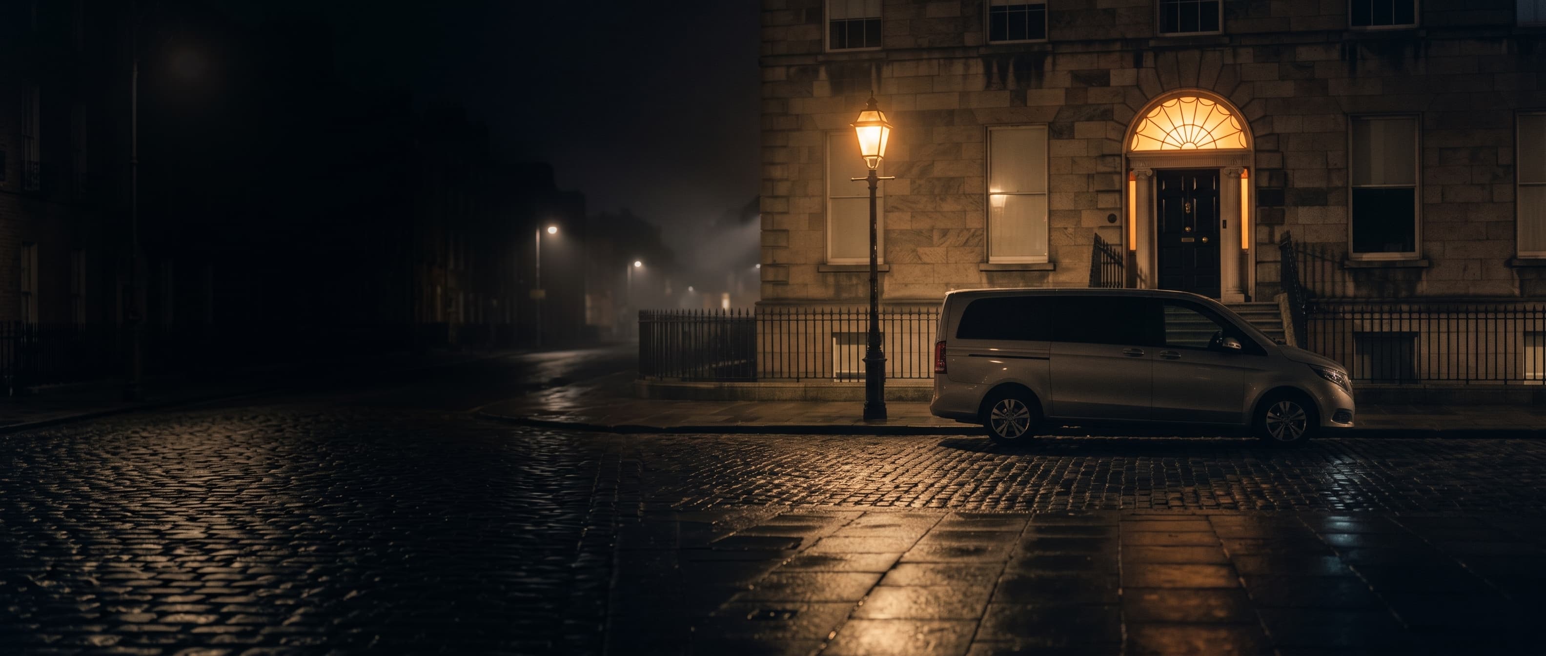 An Executive MPV waiting at night outside a Georgian townhouse