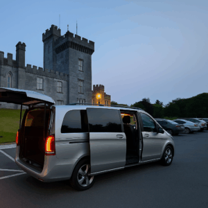 Golf Tours a silver van with open doors in a parking lot with a castle in the background